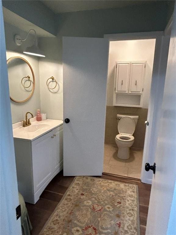 1702 Countryside Dr, Pittsburg, KS 66762 - half bath featuring vanity, wood finished floors, and toilet