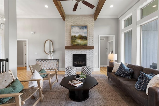 20611 W 113th St, Olathe, KS 66061 - living area featuring a ceiling fan, beam ceiling, wood finished floors, a fireplace, and a towering ceiling