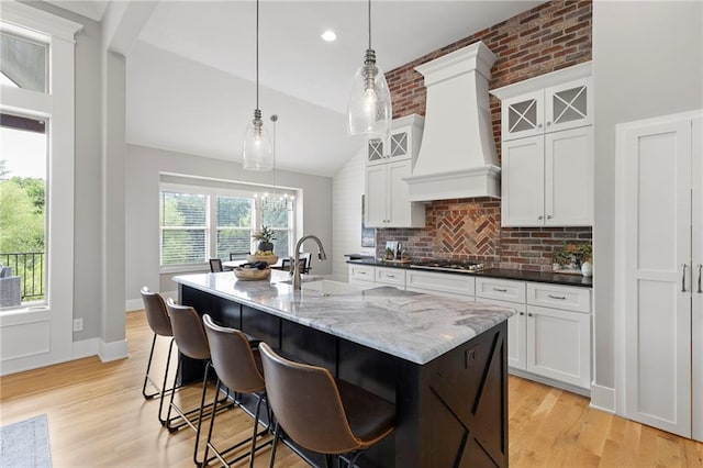 20611 W 113th St, Olathe, KS 66061 - kitchen with premium range hood, gas stovetop, lofted ceiling, a center island with sink, and tasteful backsplash