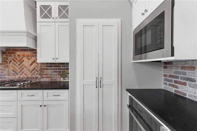 20611 W 113th St, Olathe, KS 66061 - kitchen with appliances with stainless steel finishes, dark countertops, tasteful backsplash, and white cabinetry