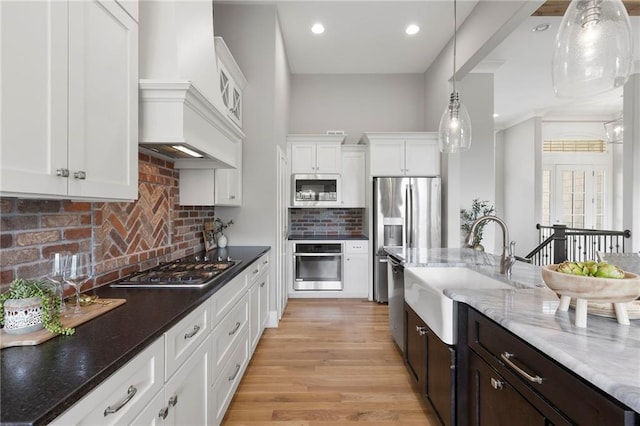20611 W 113th St, Olathe, KS 66061 - kitchen with stainless steel appliances, white cabinets, decorative light fixtures, dark brown cabinets, and tasteful backsplash