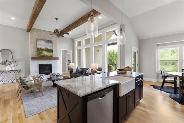 20611 W 113th St, Olathe, KS 66061 - kitchen with stainless steel dishwasher, hanging light fixtures, light stone counters, light wood-style flooring, and a kitchen island with sink