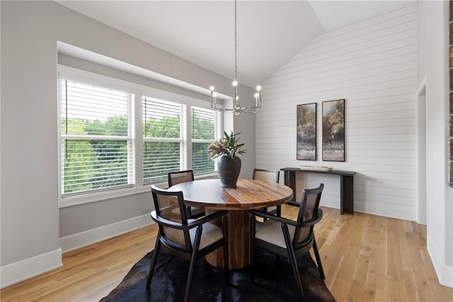 20611 W 113th St, Olathe, KS 66061 - dining space with vaulted ceiling, a chandelier, light wood-style flooring, and wooden walls