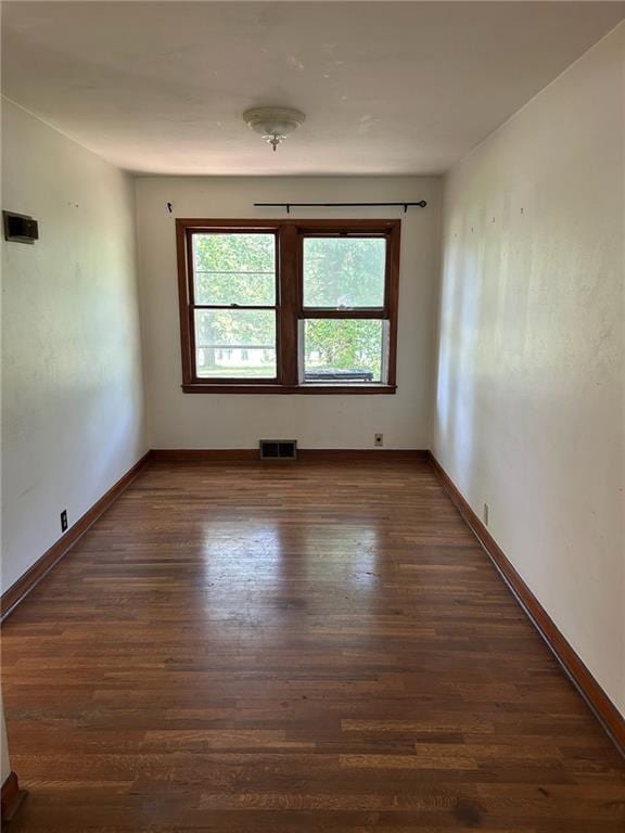 unfurnished room with wood finished floors and baseboards