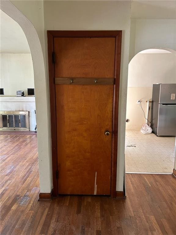 hall featuring wood finished floors and arched walkways