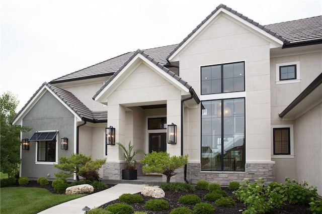 10702 W 142nd Ter, Overland Park, KS 66221 - view of front of home with stone siding, stucco siding, and a tiled roof