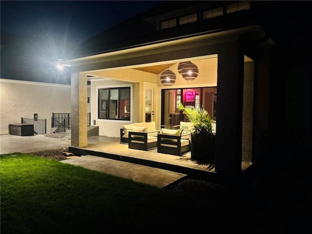 10702 W 142nd Ter, Overland Park, KS 66221 - back of house at night with stucco siding and outdoor lounge area