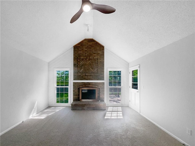 2157 E 154th St, Olathe, KS 66062 - unfurnished living room with vaulted ceiling, a fireplace, carpet floors, ceiling fan, and a textured ceiling