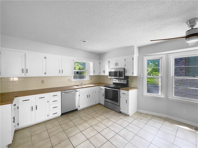 2157 E 154th St, Olathe, KS 66062 - kitchen featuring stainless steel appliances, a sink, white cabinets, healthy amount of natural light, and a textured ceiling