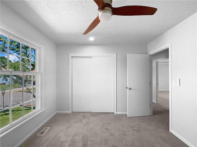 2157 E 154th St, Olathe, KS 66062 - unfurnished bedroom featuring a textured ceiling, carpet, multiple windows, and a closet