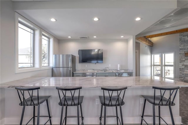 15349 W 173rd Ter, Olathe, KS 66062 - kitchen with freestanding refrigerator, a peninsula, recessed lighting, light stone countertops, and a sink