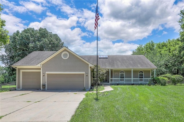 1875 E Mechanic Ave, Independence, MO 64050 - view of front of house with a porch, a front lawn, concrete driveway, a garage, and roof with shingles