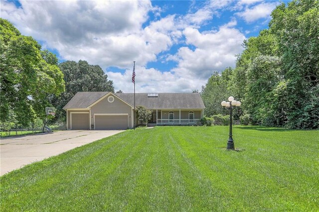 1875 E Mechanic Ave, Independence, MO 64050 - view of front of house with covered porch, a garage, concrete driveway, and a front yard