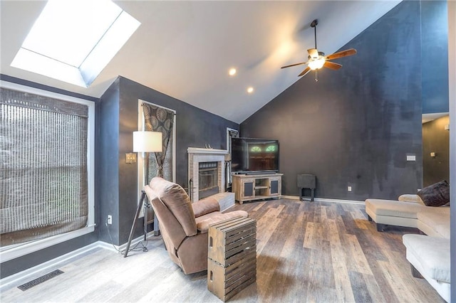 1875 E Mechanic Ave, Independence, MO 64050 - living area featuring wood finished floors, a ceiling fan, a skylight, a fireplace, and high vaulted ceiling