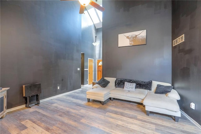 1875 E Mechanic Ave, Independence, MO 64050 - living room featuring a towering ceiling, a ceiling fan, and wood finished floors
