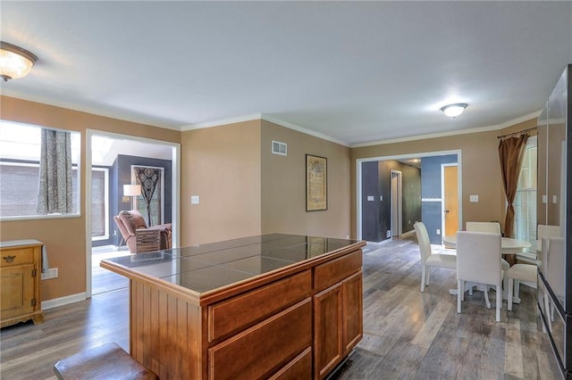 1875 E Mechanic Ave, Independence, MO 64050 - kitchen with wood finished floors, tile countertops, ornamental molding, and brown cabinetry