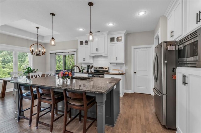 2409 SE Ridge Line Dr, Blue Springs, MO 64014 - kitchen with appliances with stainless steel finishes, a sink, a chandelier, a breakfast bar, and baseboards