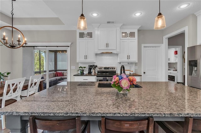 2409 SE Ridge Line Dr, Blue Springs, MO 64014 - kitchen with stainless steel appliances, a chandelier, backsplash, white cabinets, and recessed lighting
