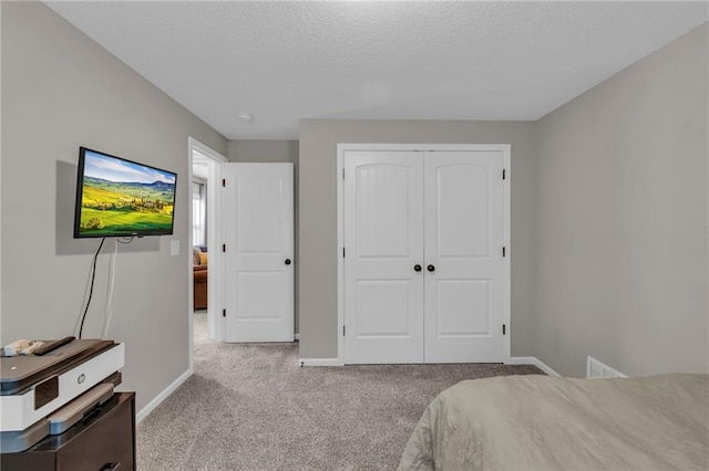 2409 SE Ridge Line Dr, Blue Springs, MO 64014 - carpeted bedroom with a closet, a textured ceiling, and baseboards