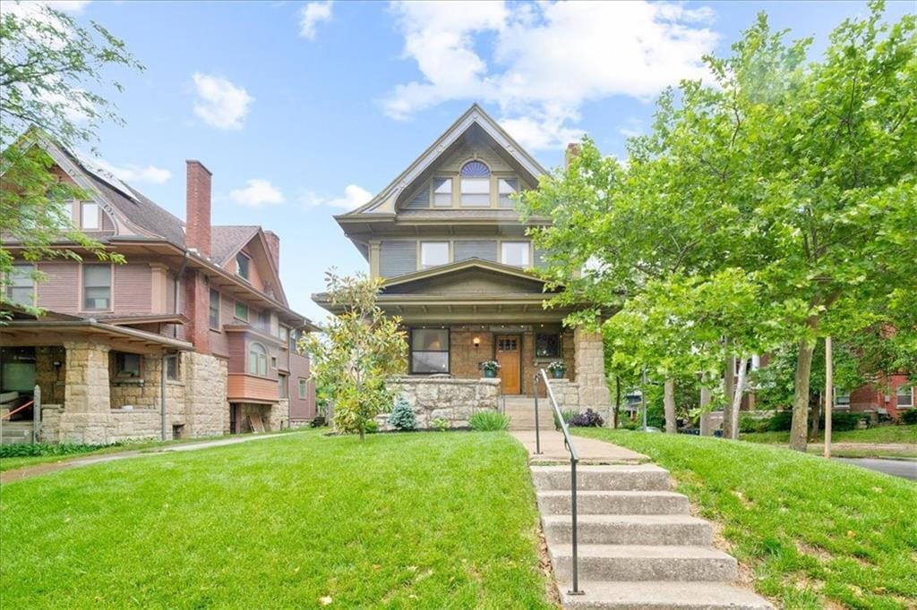4100 Harrison St, Kansas City, MO 64110 - view of front of house with a front yard, a porch, and stone siding