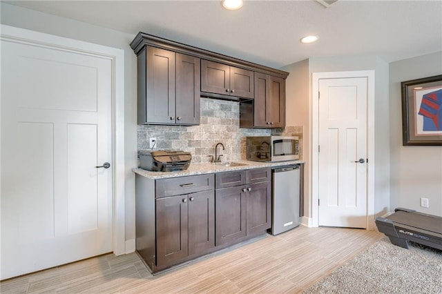 12435 Parkview Ave, Kansas City, KS 66109 - kitchen with stainless steel appliances, decorative backsplash, dark brown cabinets, a sink, and recessed lighting