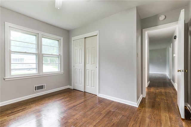 6721 Larsen Ln, Shawnee, KS 66203 - unfurnished bedroom featuring dark wood finished floors, baseboards, a closet, and a ceiling fan