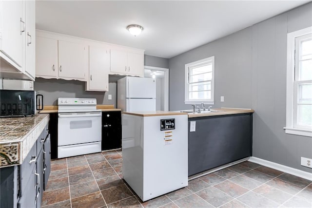 6721 Larsen Ln, Shawnee, KS 66203 - kitchen featuring white appliances, healthy amount of natural light, baseboards, and white cabinets
