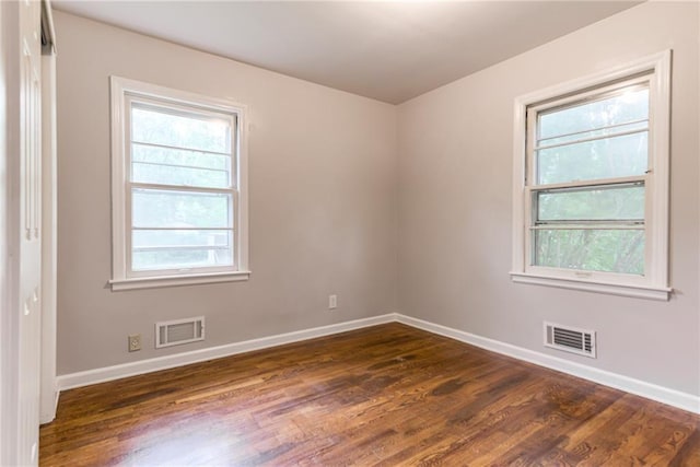 6721 Larsen Ln, Shawnee, KS 66203 - unfurnished room featuring baseboards, dark wood finished floors, and plenty of natural light