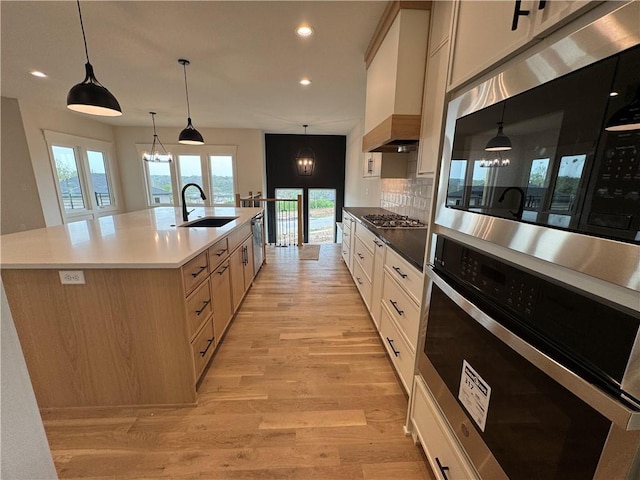 9019 Freedom Cir, Lenexa, KS 66227 - kitchen with appliances with stainless steel finishes, a sink, light wood-style floors, recessed lighting, and tasteful backsplash