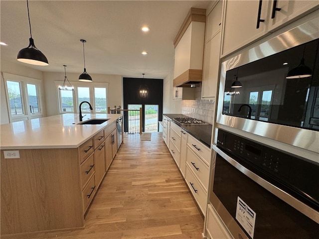 9019 Freedom Cir, Lenexa, KS 66227 - kitchen featuring appliances with stainless steel finishes, a sink, light wood-style floors, tasteful backsplash, and recessed lighting