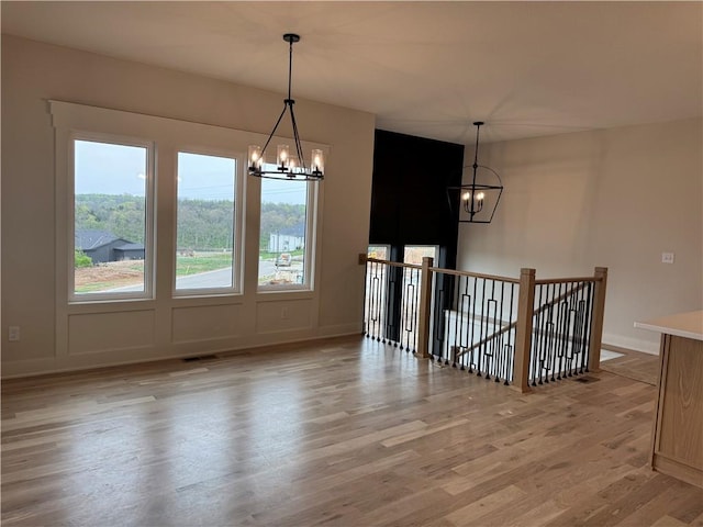9019 Freedom Cir, Lenexa, KS 66227 - unfurnished dining area featuring a chandelier and light wood finished floors