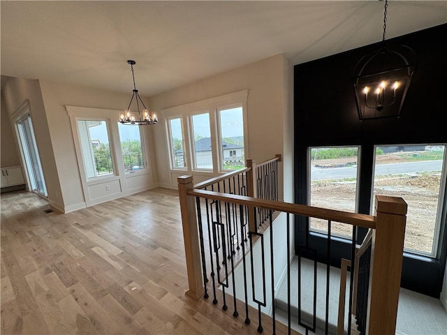 9019 Freedom Cir, Lenexa, KS 66227 - hallway featuring a chandelier, an upstairs landing, light wood-style flooring, and baseboards