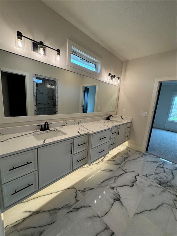 9019 Freedom Cir, Lenexa, KS 66227 - full bath featuring double vanity, marble look tile flooring, a shower, and baseboards