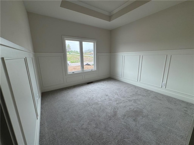 9019 Freedom Cir, Lenexa, KS 66227 - empty room featuring a decorative wall, wainscoting, carpet, and a tray ceiling
