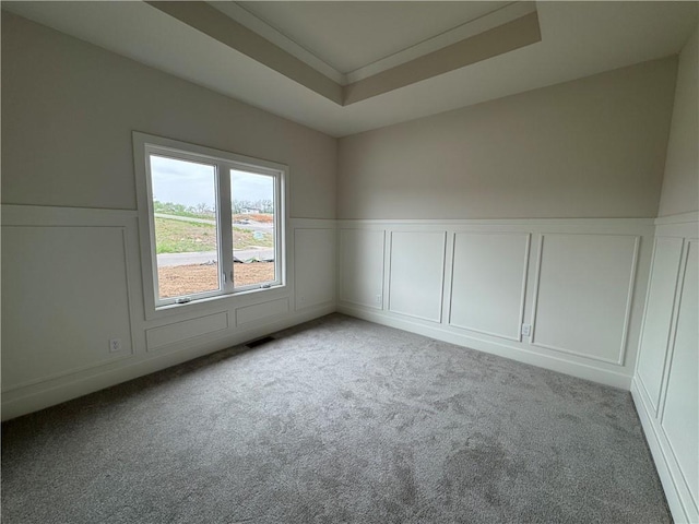 9019 Freedom Cir, Lenexa, KS 66227 - empty room featuring a decorative wall, carpet floors, a raised ceiling, a wainscoted wall, and crown molding