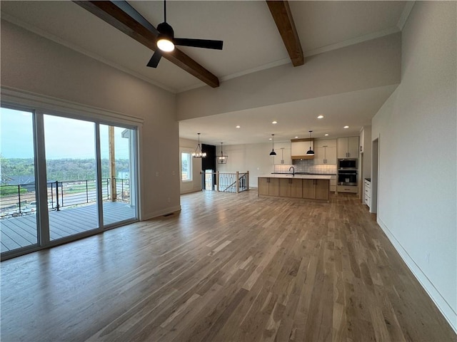 9019 Freedom Cir, Lenexa, KS 66227 - unfurnished living room with beam ceiling, wood finished floors, a ceiling fan, baseboards, and recessed lighting