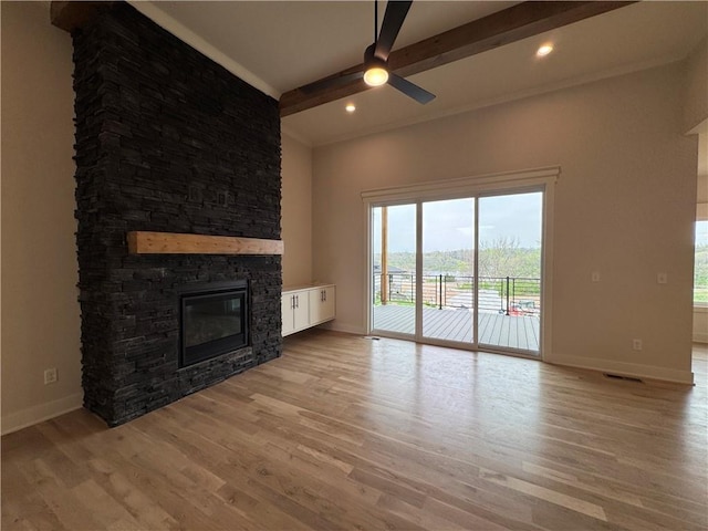 9019 Freedom Cir, Lenexa, KS 66227 - unfurnished living room featuring baseboards, beam ceiling, ceiling fan, a stone fireplace, and light wood finished floors
