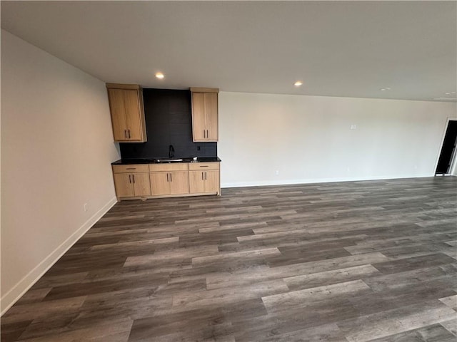 9019 Freedom Cir, Lenexa, KS 66227 - unfurnished living room with dark wood-style floors, recessed lighting, baseboards, and a sink