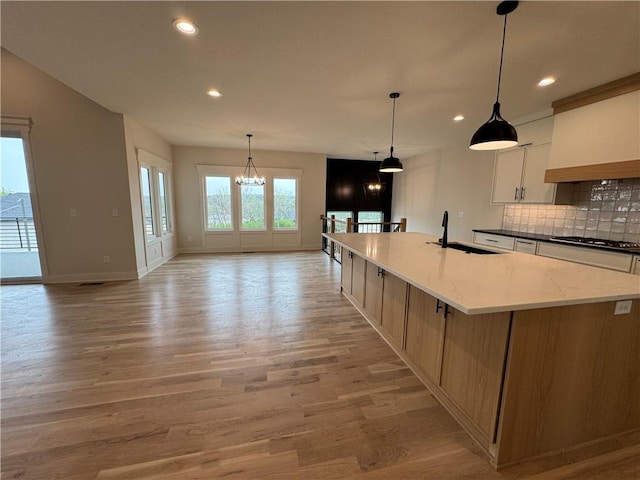 9019 Freedom Cir, Lenexa, KS 66227 - kitchen with light wood-style floors, tasteful backsplash, recessed lighting, a large island, and a chandelier