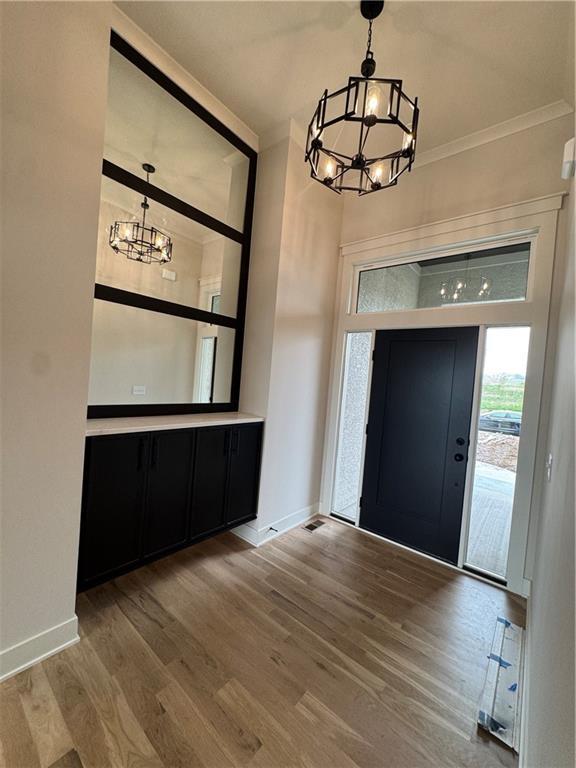 9019 Freedom Cir, Lenexa, KS 66227 - foyer entrance with a chandelier, ornamental molding, and wood finished floors