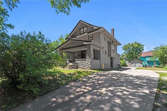 3218 Benton Blvd, Kansas City, MO 64128 - view of front of house with stone siding, covered porch, a chimney, driveway, and stucco siding