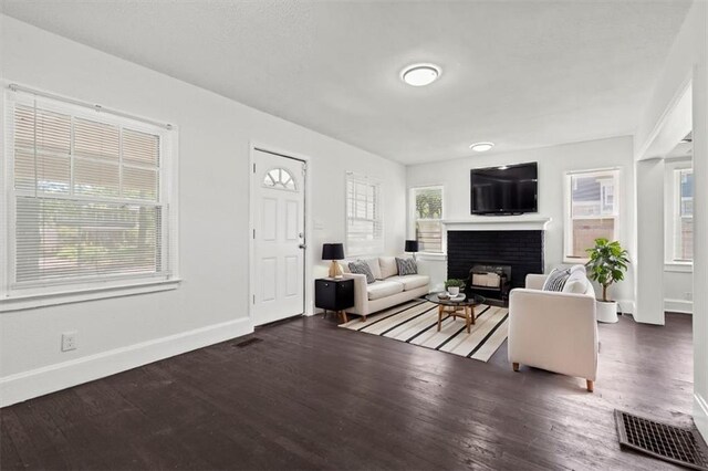 3218 Benton Blvd, Kansas City, MO 64128 - living area with a fireplace, baseboards, and wood finished floors