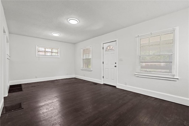 3218 Benton Blvd, Kansas City, MO 64128 - entryway featuring baseboards, dark wood-style floors, and a textured ceiling