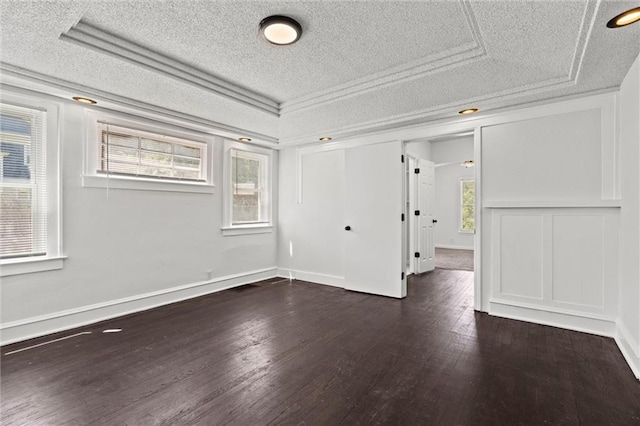 3218 Benton Blvd, Kansas City, MO 64128 - unfurnished bedroom with a textured ceiling, dark wood-style flooring, multiple windows, a closet, and baseboards