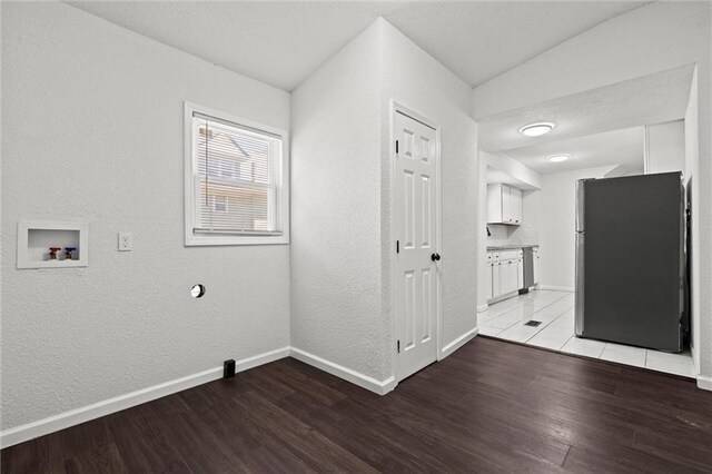 3218 Benton Blvd, Kansas City, MO 64128 - washroom with light wood-style floors, baseboards, a textured wall, and washer hookup