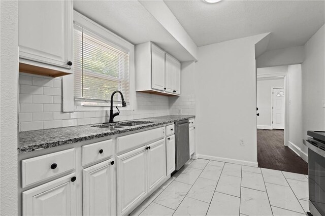 3218 Benton Blvd, Kansas City, MO 64128 - kitchen with a sink, appliances with stainless steel finishes, white cabinetry, light marble finish flooring, and tasteful backsplash