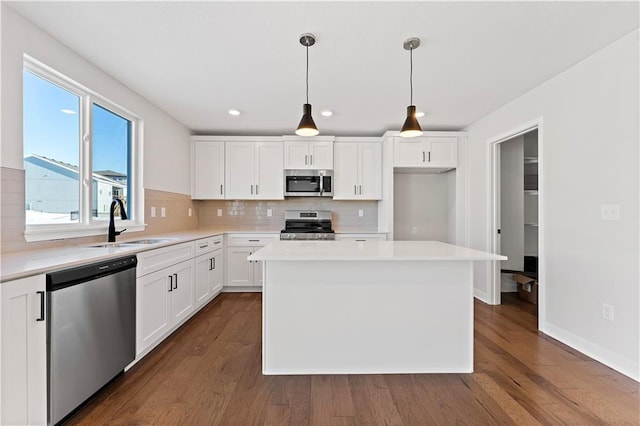338 Meadowlark Dr, Raymore, MO 64083 - kitchen featuring stainless steel appliances, a sink, tasteful backsplash, dark wood-style flooring, and white cabinets