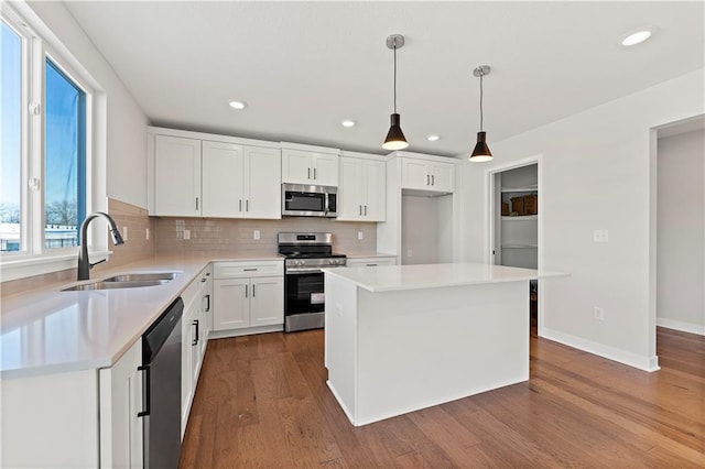 338 Meadowlark Dr, Raymore, MO 64083 - kitchen with stainless steel appliances, a sink, backsplash, dark wood-type flooring, and light countertops