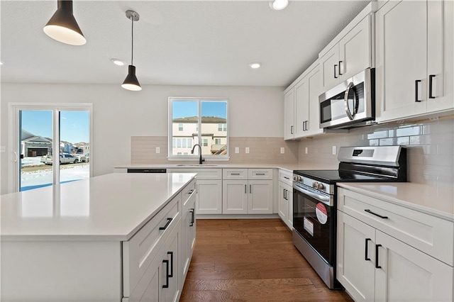 338 Meadowlark Dr, Raymore, MO 64083 - kitchen featuring appliances with stainless steel finishes, a sink, healthy amount of natural light, a center island, and recessed lighting
