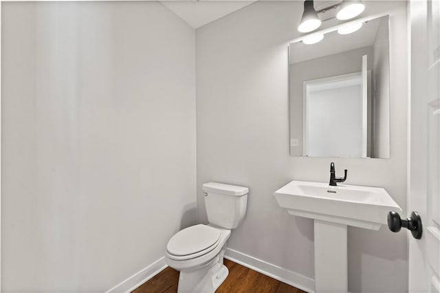 338 Meadowlark Dr, Raymore, MO 64083 - half bathroom featuring baseboards, wood finished floors, toilet, and a sink